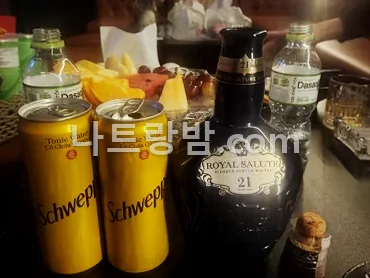 버니 라운지바 테이블에 올린 위스키 한 병과 탄산음료 캔