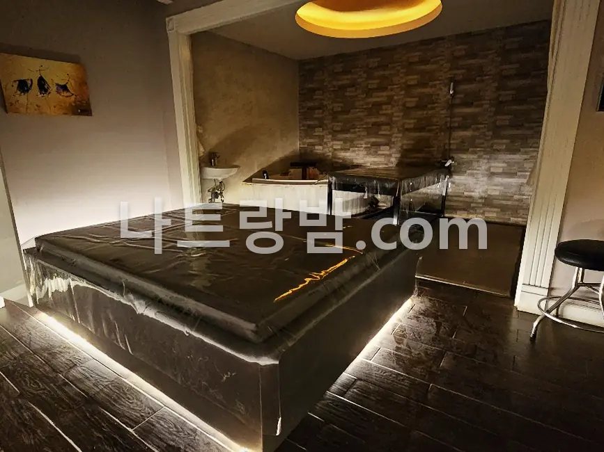 벽돌 벽 아래 사각 침대를 놓은 체리스파 개별 관리실