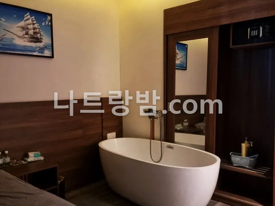 흰 욕조와 침대를 한 방에 둔 클라우드나인 관리실