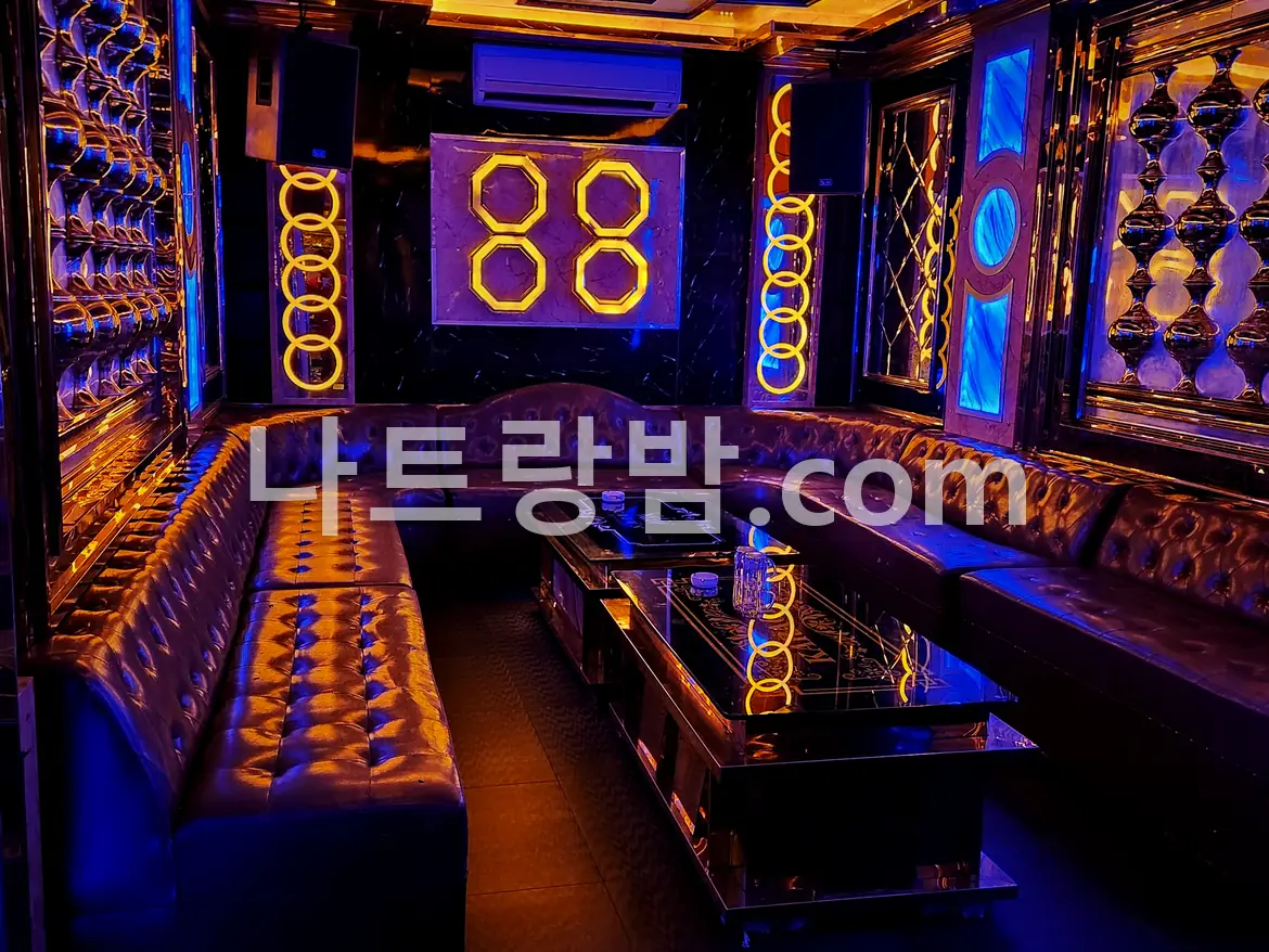 보라 조명이 벽 전체를 덮은, 크라운 가라오케가 쓰던 룸과 긴 소파