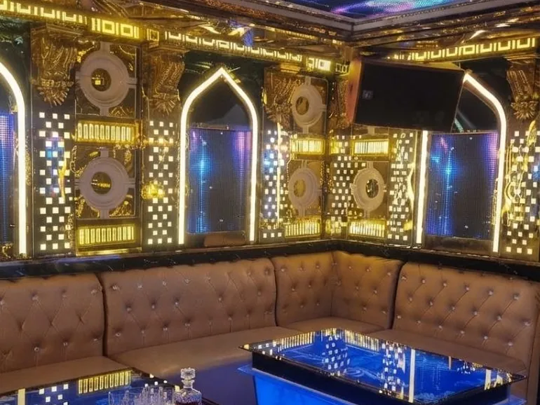 금색 아치 패널과 파란 LED 테이블을 둔 갈리나 가라오케 룸