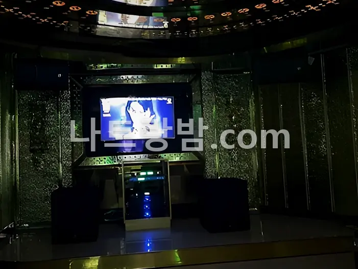 원형 로고 조명을 천장에 올린 리버티 가라오케 룸과 화면