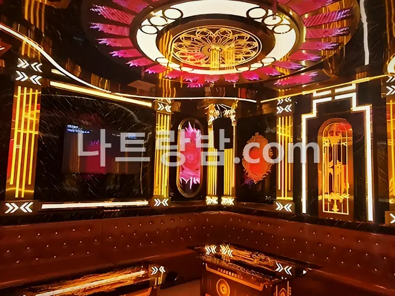 호박색 조명으로 벽을 채운 뉴시티 가라오케 객실