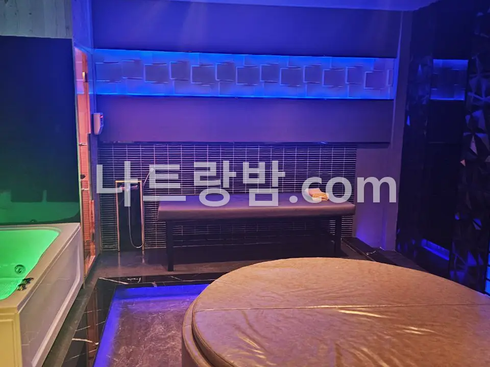 파란 간접조명 아래 원형 침대를 놓은 나우스파 객실