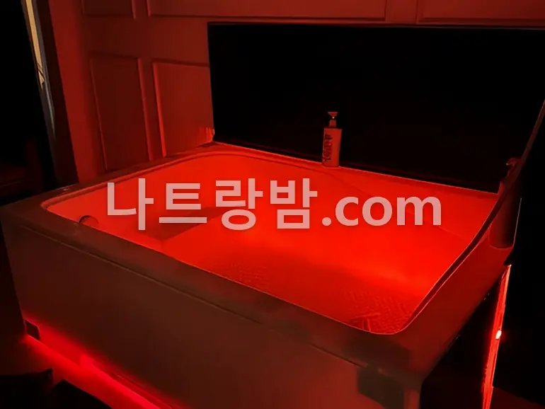 붉은 조명 아래 뚜껑을 연 사쿠라 마사지의 좌훈 상자