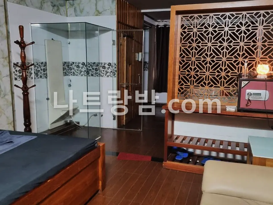 목재 칸막이로 나눈 도쿄마사지 관리실의 베드와 소파