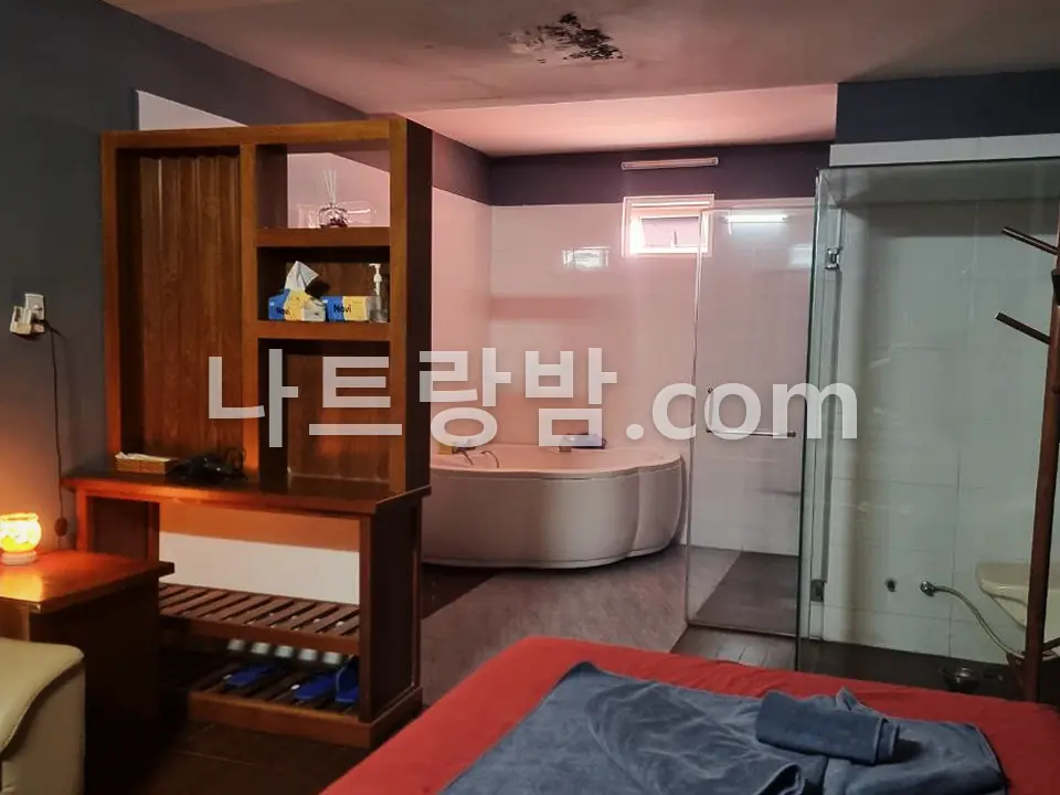 붉은 침구를 깐 도쿄마사지 관리 베드와 수납장